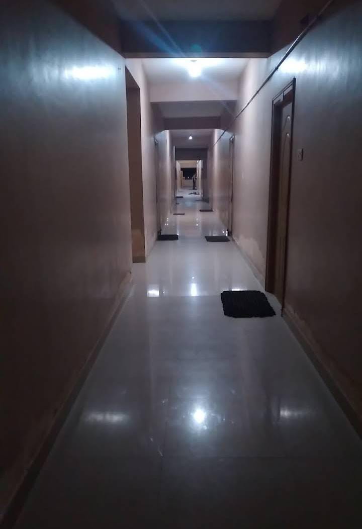 Long tiled corridor lined with guest room doors inside Gujarat Bhavan Rameswaram